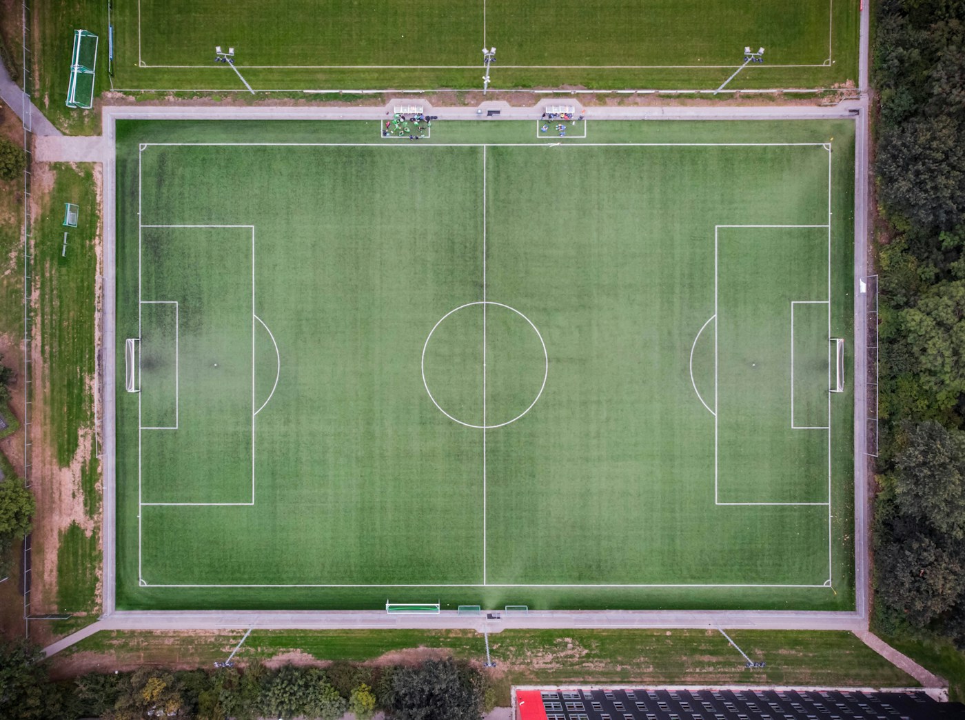 Yukarıdan boş futbol sahası; kulüp rehberi kapsam görseli, marka yok.